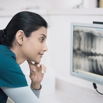 Dentist examining dental X-ray on a monitor