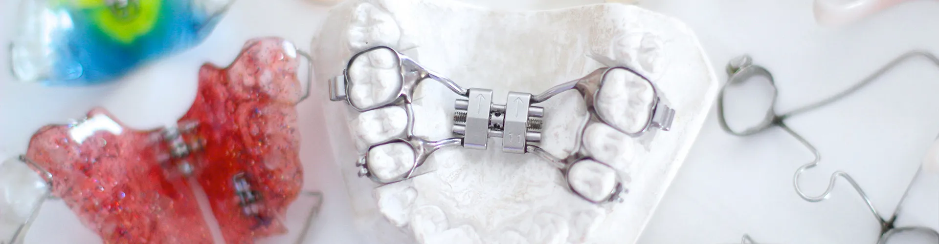 bite plate on mouth model surrounded by retainers