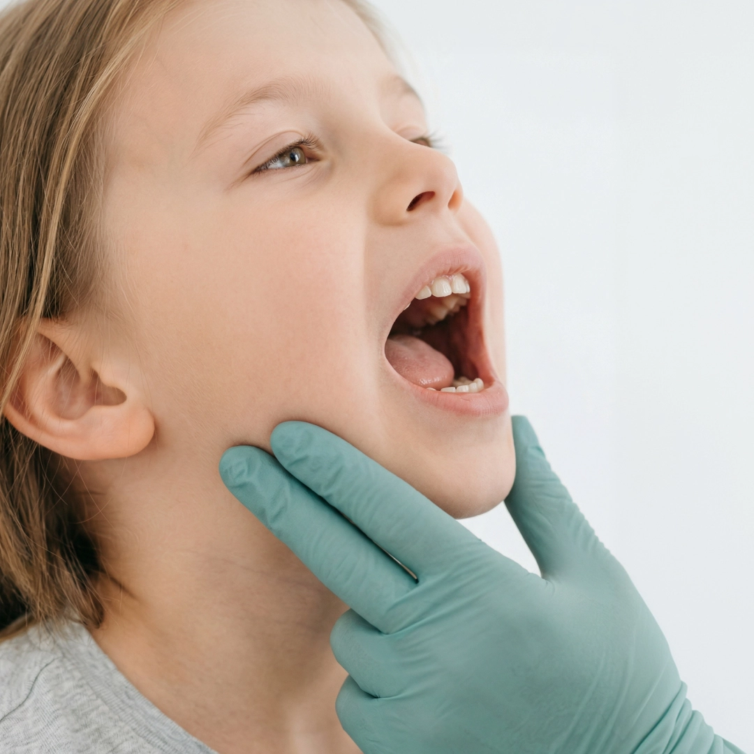 Doctor examining child’s throat during medical checkup in clinic