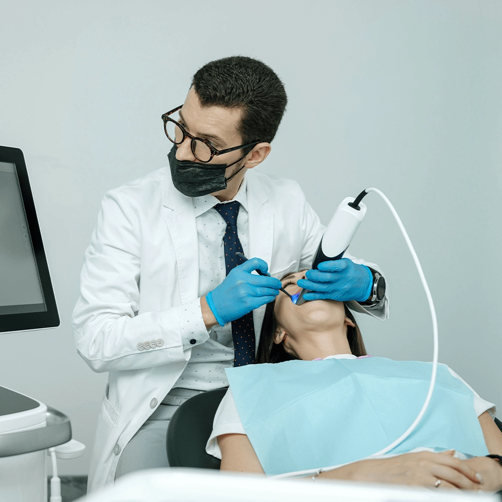 Dentist and assistant using digital x-ray technology to examine patient.